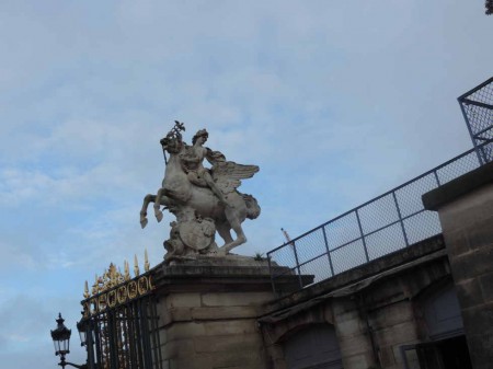 De chaque côté de la grille, deux statues d'Antoine Coysevox. Ici Mercure.